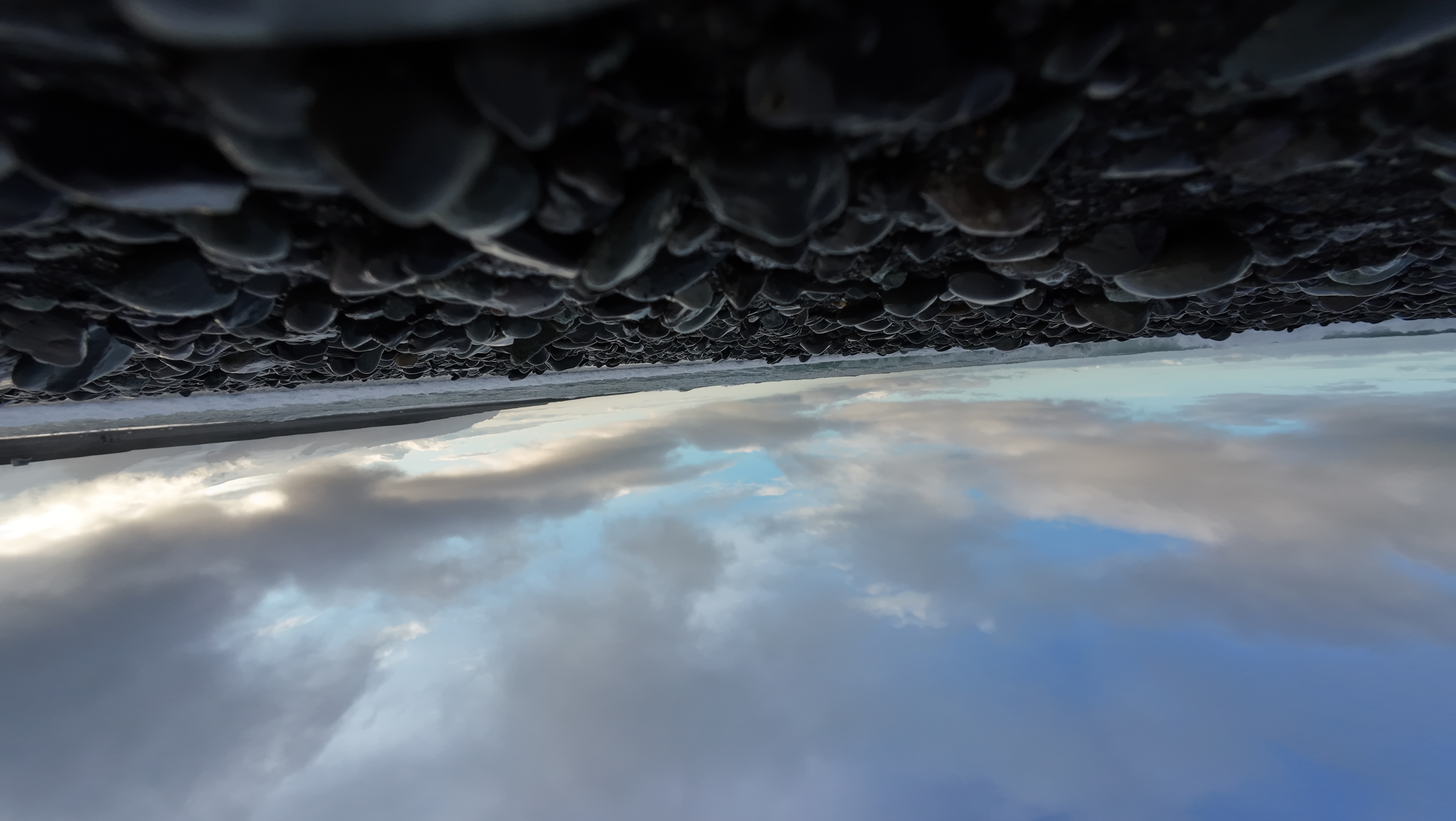 Black pebbles infront of ocean like a black sand beach